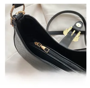 Close-up of black crocodile texture bag featuring smooth golden zipper and hardware