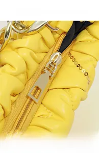Makro-Detail von gelbem gerafftem Leder mit Pailletten und goldenem Metallreißverschluss