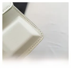 Close-up of white leather texture and neat stitching on fashion square bag
