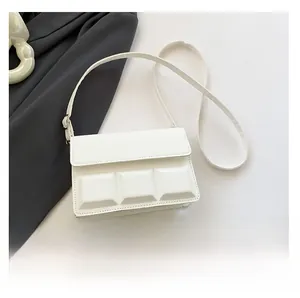Detailed view of the white checkered crossbody bag with textured flap and slim strap