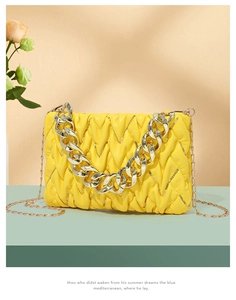 Detailsicht der gelben Stepptasche mit Pailletten-Akzenten und goldener Deko-Kette
