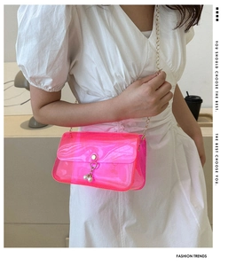 Détail du sac gelée rose transparent en PVC avec chaîne dorée et perles