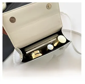 Interior view showing the storage capacity for a phone and makeup in this white crossbody bag