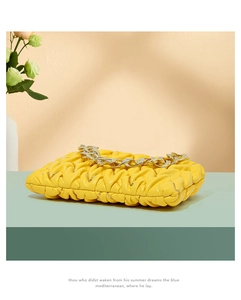Detailaufnahme der gelben Falten-Umhängetasche mit goldener Kette im Cloud-Stil