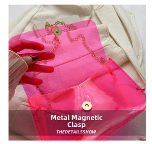 Détail du fermoir magnétique doré sur le sac à chaîne en PVC rose transparent