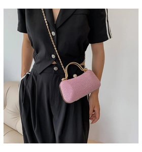 Pink sequin evening clutch bag with gold handle and chain strap worn by a model