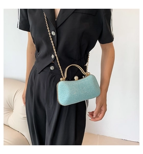 Detail of light blue sequined evening bag with gold metal handle and pearl clasp