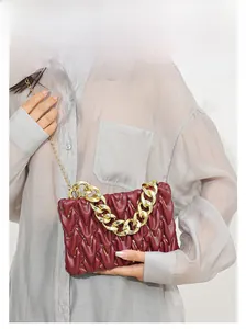 Nahaufnahme der weinroten Faltenledertasche mit goldenen Pailletten und Metallkette