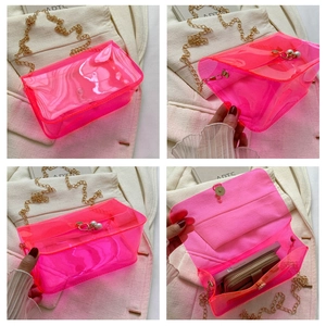 Détail du sac en PVC rose transparent avec chaîne dorée et pendentif en perle