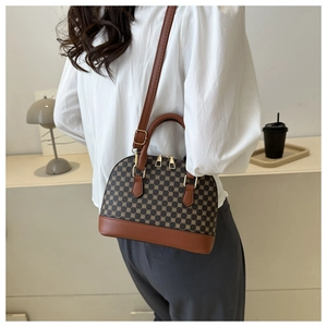 Detail van vintage schelptas met bruine lederen riemen en goudkleurige hardware