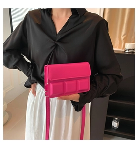 Detail of fuchsia chocolate square crossbody bag with embossed flap and slim strap