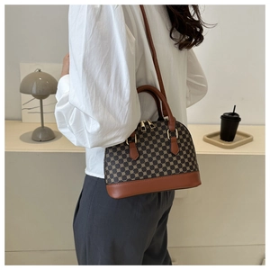 Borsa a conchiglia monogramma marrone con doppia zip indossata a tracolla da modella