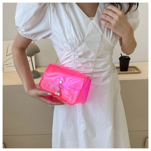 Détail du sac gelée rose néon en PVC transparent avec chaîne dorée et fermoir perle