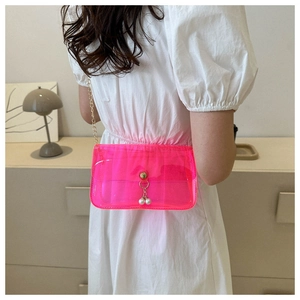 Détail du sac transparent en PVC rose néon avec chaîne dorée et perles blanches