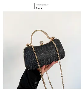 Detail of black glitter evening clutch with golden metal handle and rhinestone clasp