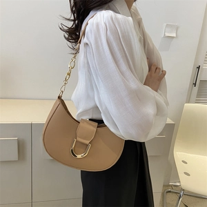 Elegant khaki half-moon underarm bag with gold metal clasp and chain strap on model