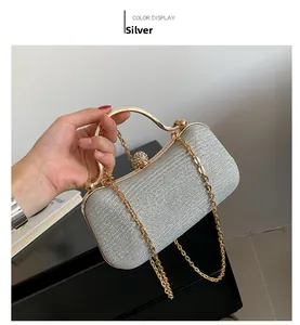 Detail of silver glitter evening clutch with gold metal handle and rhinestone clasp