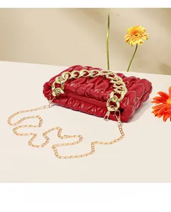 Nahaufnahme der roten Falten-Cloud-Tasche mit goldener Kette und Blumendeko