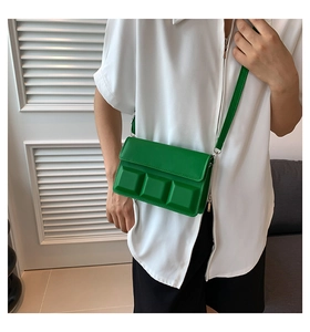 Model wearing a green checkered small square crossbody bag with 3D chocolate block texture