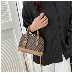 Detailopname van retro schelp-handtas met geometrische patronen en gouden hardware