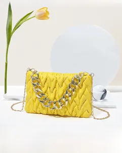 Detail der gelben Stepptasche mit V-Textur und goldener Kettenhenkel-Dekoration