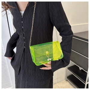 Détail du sac en PVC transparent vert néon avec breloques perles et bandoulière dorée
