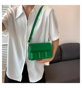 Detail of bright green crossbody bag with 3D chocolate bar embossed pattern on white shirt