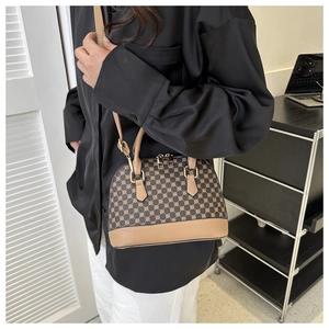 Detail van retro schelp-tas met geometrische print, lederen bies en gouden metalen details
