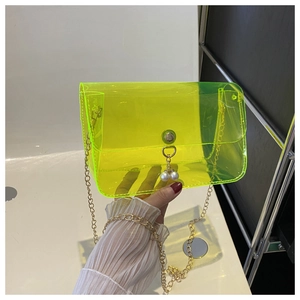 Détail du sac gelée transparent en PVC vert néon avec chaîne dorée et perle décorative