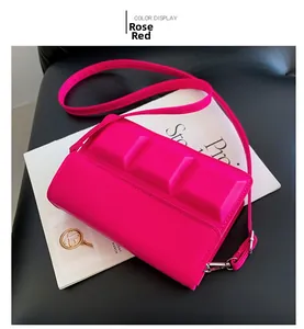 Detail of rose red crossbody bag with chocolate square pattern and silver buckle