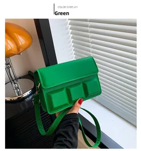 Detail of bright green square bag with 3D cube accents and adjustable shoulder strap
