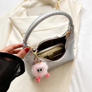 Detail showing inner capacity of grey shoulder bag with phone and wallet inside
