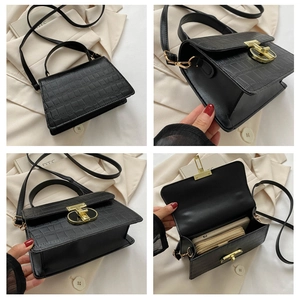 Detail view of black crocodile pattern bag showing texture, gold clasp and inner space
