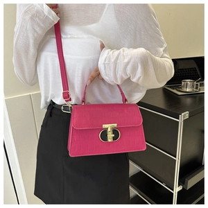 Detail of rose pink crocodile pattern handbag with gold twist lock and adjustable strap