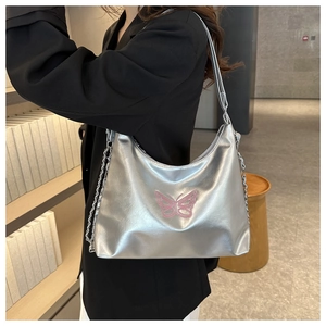 Detail of silver metallic shoulder bag with pink butterfly embroidery and metal chain strap