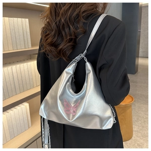Detail of silver metallic hobo bag featuring pink embroidered butterfly on the back