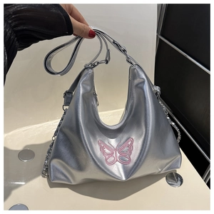 Detailed close-up of metallic silver hobo bag with pink embroidered butterfly and chain