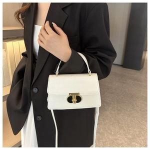 Close-up of white crocodile pattern shoulder bag with a gold T-shaped lock detail