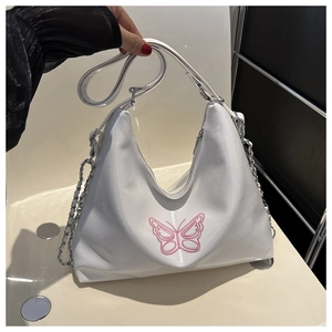 Close-up of a white crescent hobo bag with pink butterfly embroidery and chain strap