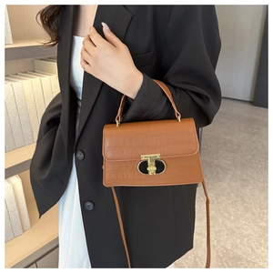 Brown crocodile pattern handbag featuring a gold clasp lock and detachable shoulder strap