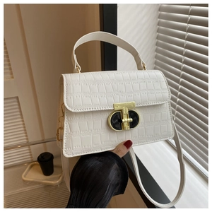 Close-up of white crocodile pattern leather handbag with gold swivel lock and handle
