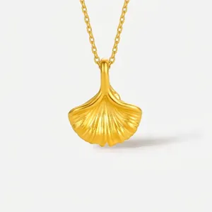 Collier pendentif feuille de ginkgo plaqué or 18k avec chaîne fine sur fond gris