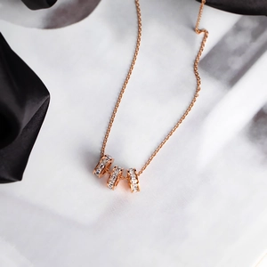 Rose gold triple interlocking cylinder necklace with micro-pave cubic zirconia crystals