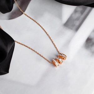 Elegant rose gold triple ring necklace with sparkling zircon crystals on white background