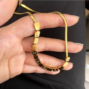 18K gold plated snake chain necklace with engraved square charms on black background