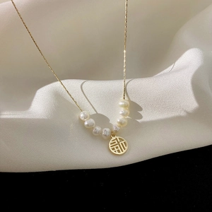 Elegant gold titanium steel necklace featuring white pearls and a hollow Fu charm pendant
