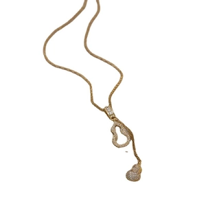 Détail d'un pendentif double gourde doré serti de cristaux sur une chaîne élégante