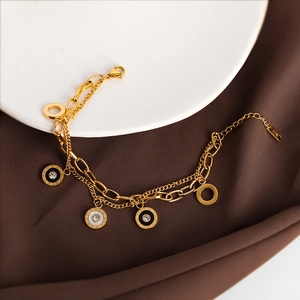 Double-layered gold titanium bracelet featuring white shell, Roman numeral charms, and crystals