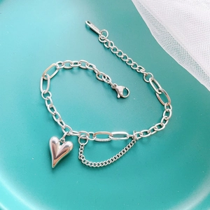 Détail du charm cœur et du fermoir mousqueton sur bracelet en acier inoxydable