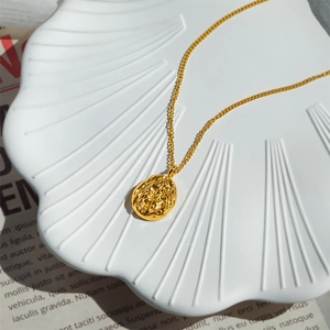 French luxury 18K gold plated titanium necklace with an oval lava texture pendant